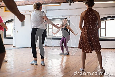 Happy young instructor teaching twist dance steps Stock Photo