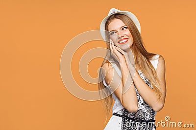 Happy young joyful woman looking sideways in excitement. Isolated over orange background Stock Photo