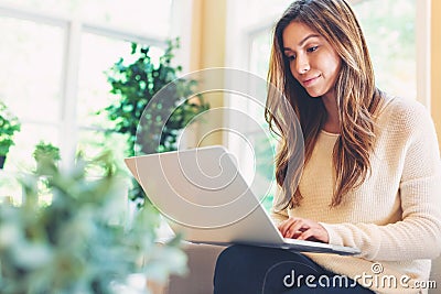 Happy young latina woman using her laptop at home Stock Photo