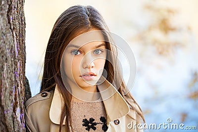 Happy young little girl in beige coat Stock Photo