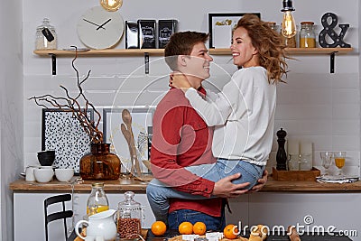 Happy young lovely couple on kitchen hugging each other. They enjoy spending time togehter Stock Photo