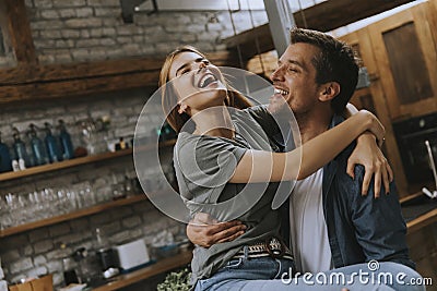 Happy young lovely couple in the kitchen hugging each other Stock Photo
