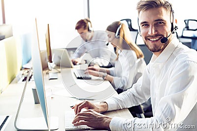 Happy young male customer support executive working in office. Stock Photo