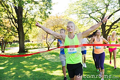 Happy young male runner winning on race finish Stock Photo