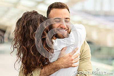 Happy Young Man Hugging His Wife At Airport After Flight Arrival Stock Photo