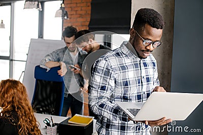 Happy young man wearing glasses working on his laptop Stock Photo