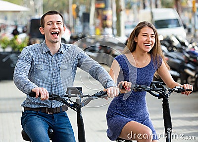 Happy young man and woman with electrkc bikes Stock Photo
