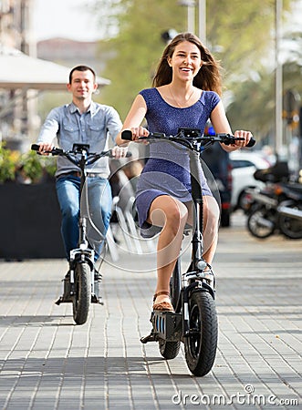 Happy young man and woman with electrkc bikes Stock Photo