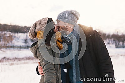 A happy young man and woman kissing in winter enjoying life and Stock Photo