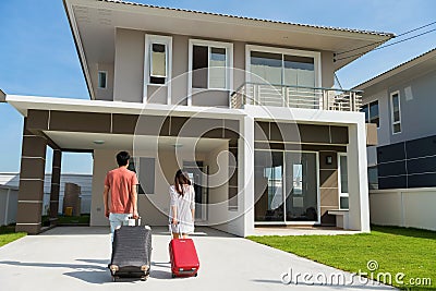 Couple pull luggage to move to new house Stock Photo