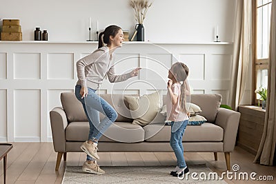 Happy mom and little kid daughter laughing dancing at home Stock Photo