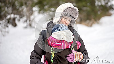 Happy young mother carrying her baby in a carrier Stock Photo