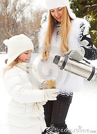 Happy young mother with daughter on winter picnic Stock Photo