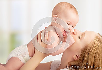Happy young mother kissing a baby Stock Photo
