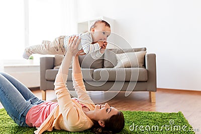 Happy young mother playing with baby at home Stock Photo