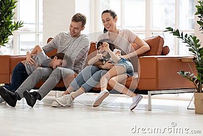 Happy parents have fun playing with preschooler children Stock Photo