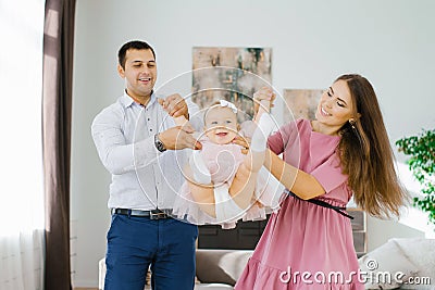 Happy young parents swing their daughter in their arms, toss it up. Happy family time Stock Photo