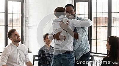 Happy young people hug engaged in group motivation training Stock Photo