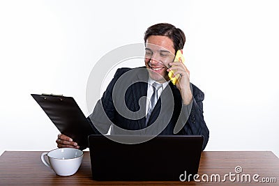 Happy young Persian businessman smiling and talking on mobile ph Stock Photo