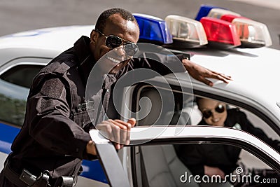 happy young police officers with car looking Stock Photo