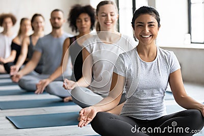 Happy young pretty indian ethnicity woman sitting in lotus pose. Stock Photo