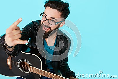 Happy young punk rocker with a guitar and dark sunglasses Stock Photo