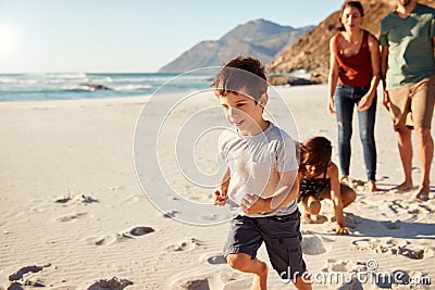 Happy young white family on holiday exploring a beach together, full length, close up Stock Photo