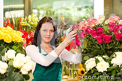 Happy young woman arranging flowers florist shop Stock Photo