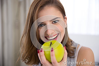 Happy young woman bitting green apple Stock Photo