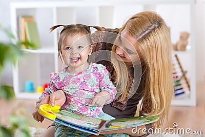 Happy young woman and child girl watching a baby booklet Stock Photo