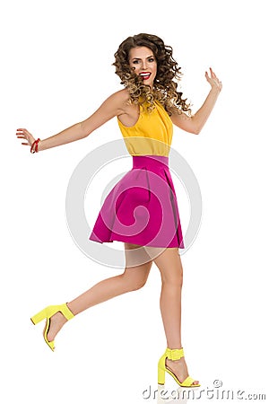 Happy Young Woman In Colorful High Heels And Pink Mini Skirt Is Running Stock Photo