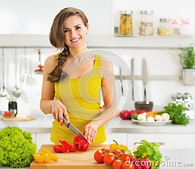 Happy young woman cutting fresh vegetable salad Stock Photo