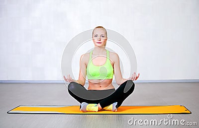 Happy young woman doing yoga exercises sitting in lotus position Stock Photo