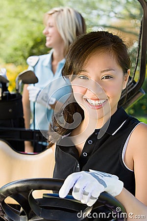 Happy Young Woman Driving Golf Cart Stock Photo