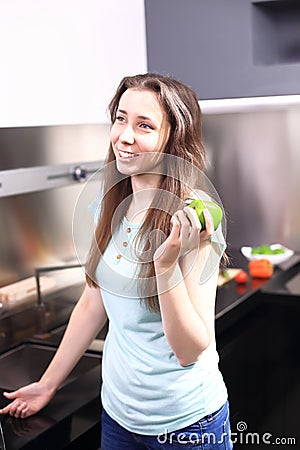 Happy young woman eating apples on kitchen Stock Photo