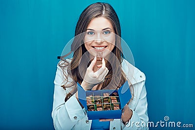 Happy young woman eating chocolate candies. Stock Photo