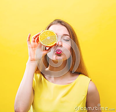 Happy young woman holding a half orange Stock Photo