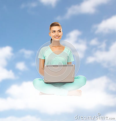 Happy young woman with laptop sitting on cloud Stock Photo