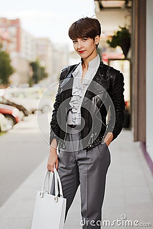 Happy young fashion woman in leather jacket with handbag Stock Photo