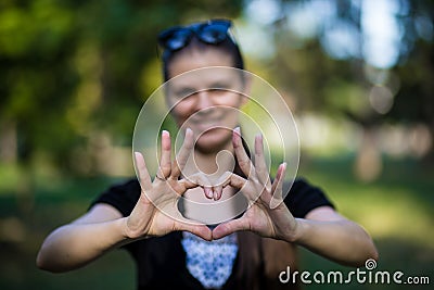Young woman makes hands in shape of love heart Stock Photo