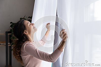 Happy young woman open curtains welcome new day Stock Photo