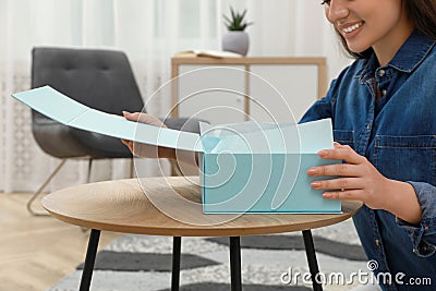 Happy young woman with parcel at home, closeup. Internet shopping Stock Photo