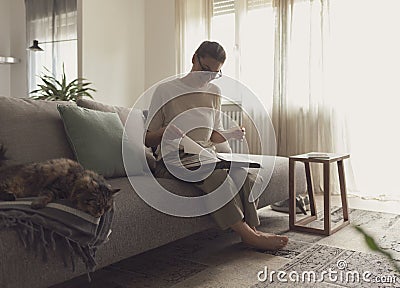 Woman relaxing on the sofa and watching pictures in the photo album Stock Photo