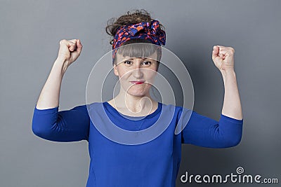 Happy young woman with retro look raising her arms for victory Stock Photo