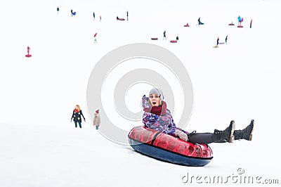 Happy young woman riding on the tubing. Inflatable sledges. Stock Photo