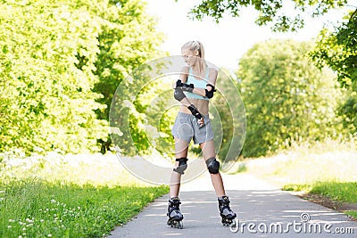 Happy young woman in rollerblades riding outdoors Stock Photo