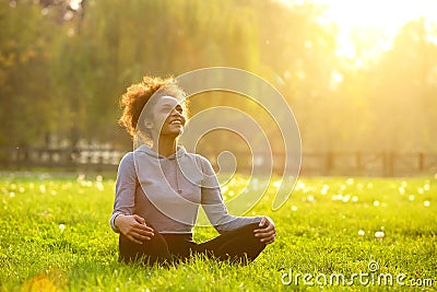 Happy young woman sitting in yoga position Stock Photo