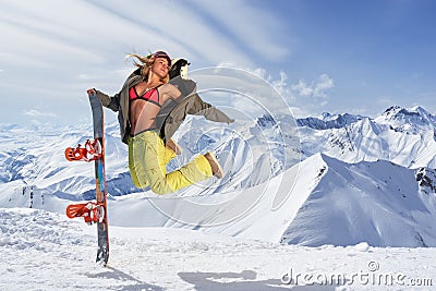 Happy young woman with snowboard jumping in winter sportswear Stock Photo