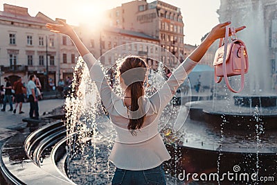 Happy young woman tourist looks at fountain. Summer travel. Vacation and holidays concept Stock Photo