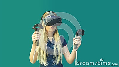 Happy young woman using joystick playing games on virtual reality glasses indoor Stock Photo